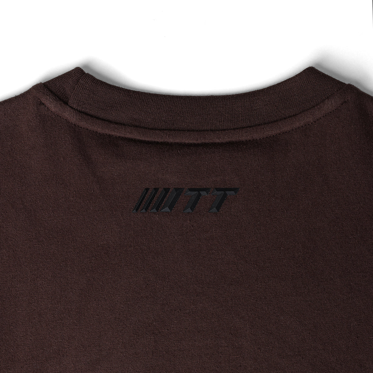 Close up image of Turbo Threads Coffee Box Fit Tee featuring a small black Turbo Threads logo near the collar