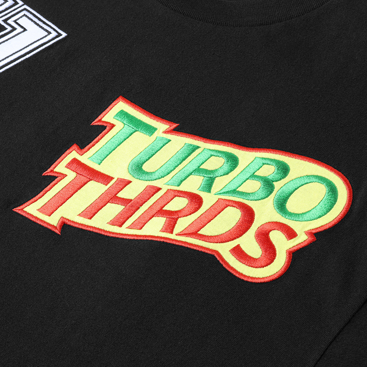 Close up image of Turbo Threads Black Box Fit Tee with yellow, green & red Turbo Threads Days Of Thunder inspired logo.