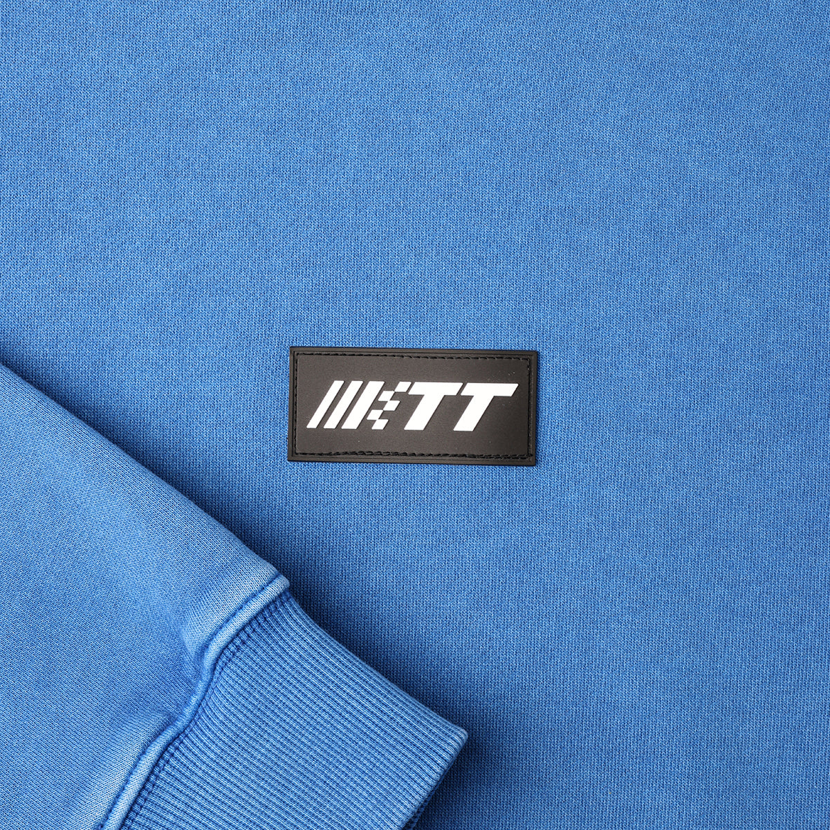 Close up image of Turbo Threads Pigment Blue Box Fit Hoodie featuring a black and white Turbo Threads logo