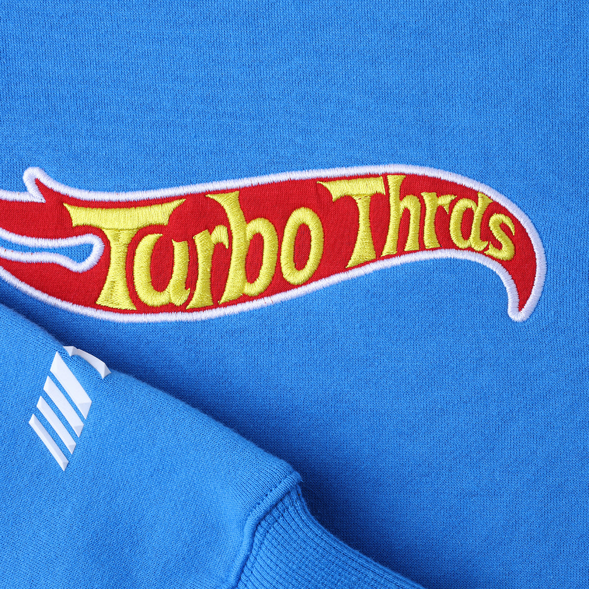 Close up image of Turbo Threads French Blue Box Fit Hoodie with embroidered red and yellow Hot Wheels inspired logo 