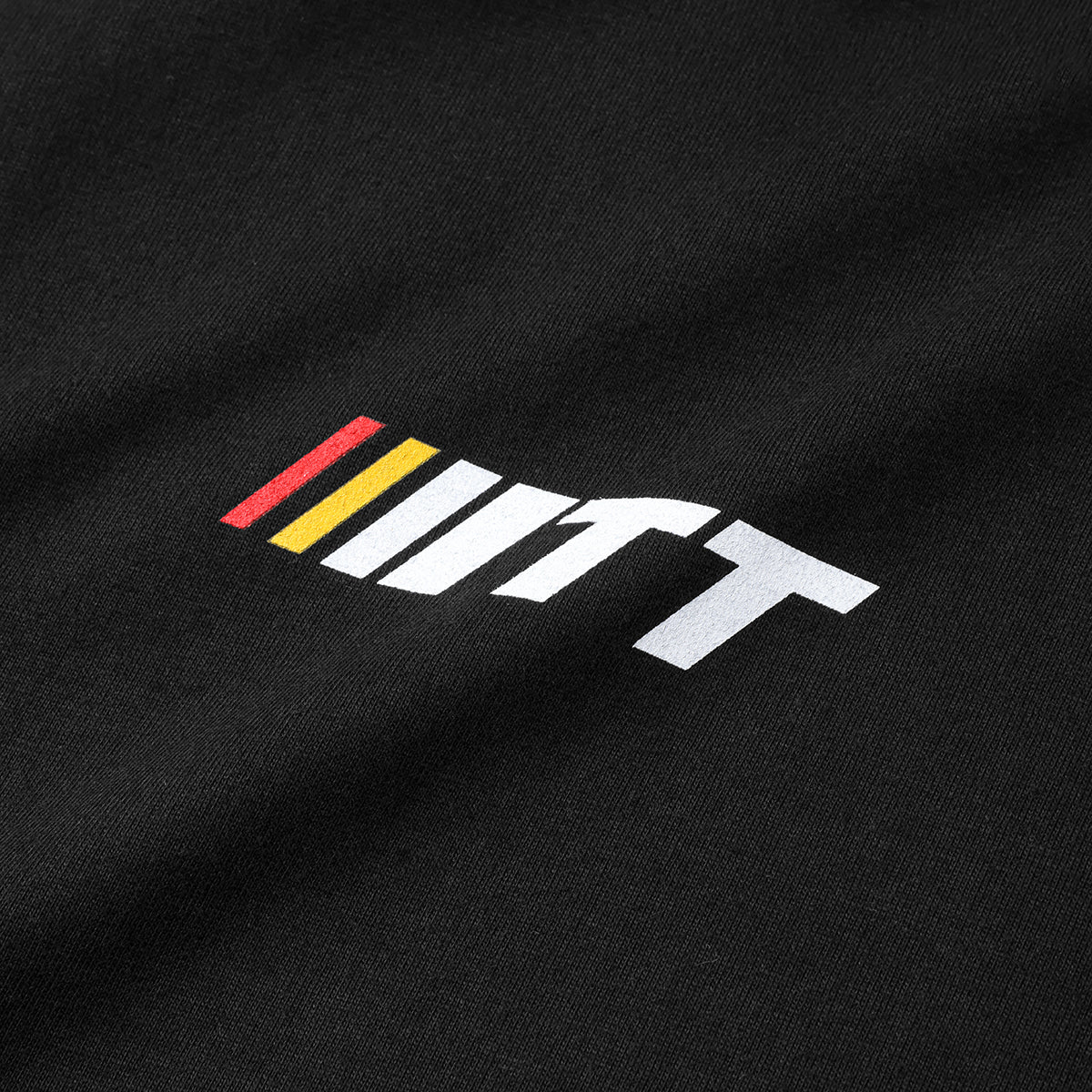 Close up shot of red yellow and white Turbo Threads logo on black tee