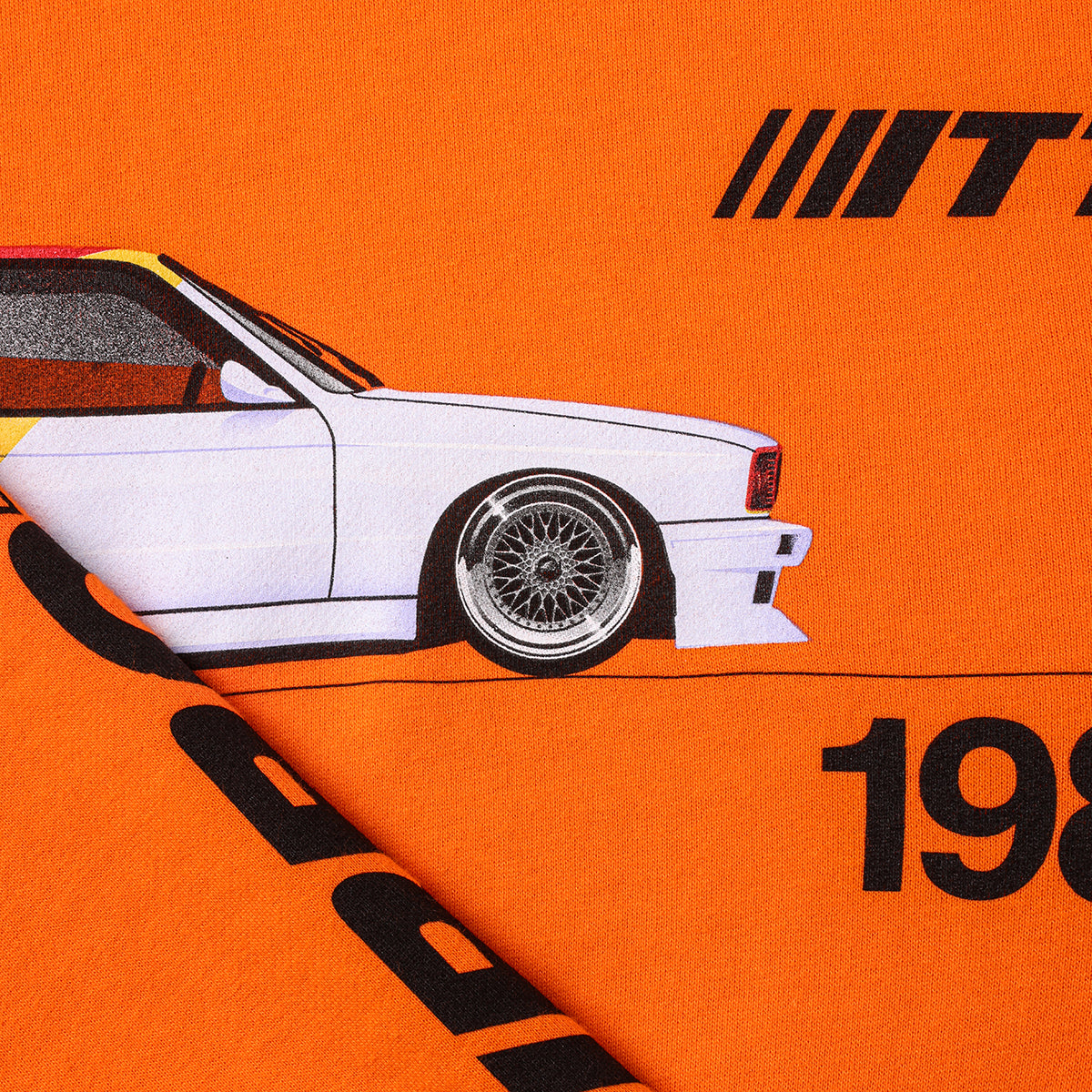 close up shot of Turbo Threads scarlet orange standard fit hoodie with a BMW E30 M3 graphic and black text